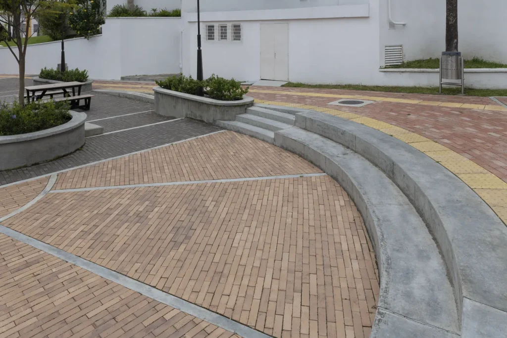 Zona peatonal con banca curva en concreto pavimentada en Adoquín Cuarto 26 Cobrizo de Ladrillera Santafé